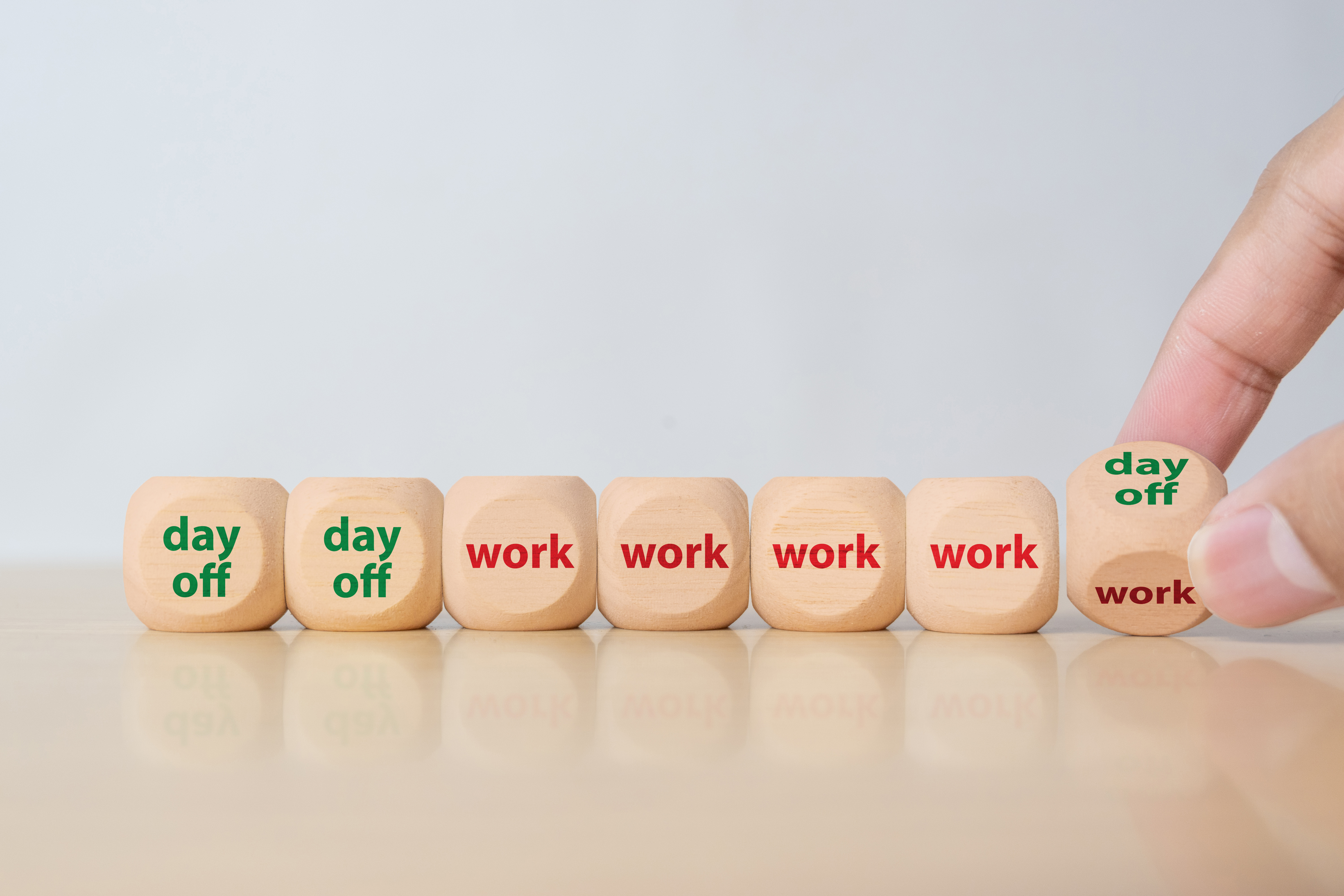 Wooden blocks illustrating a four-day working week and a scheduled day off